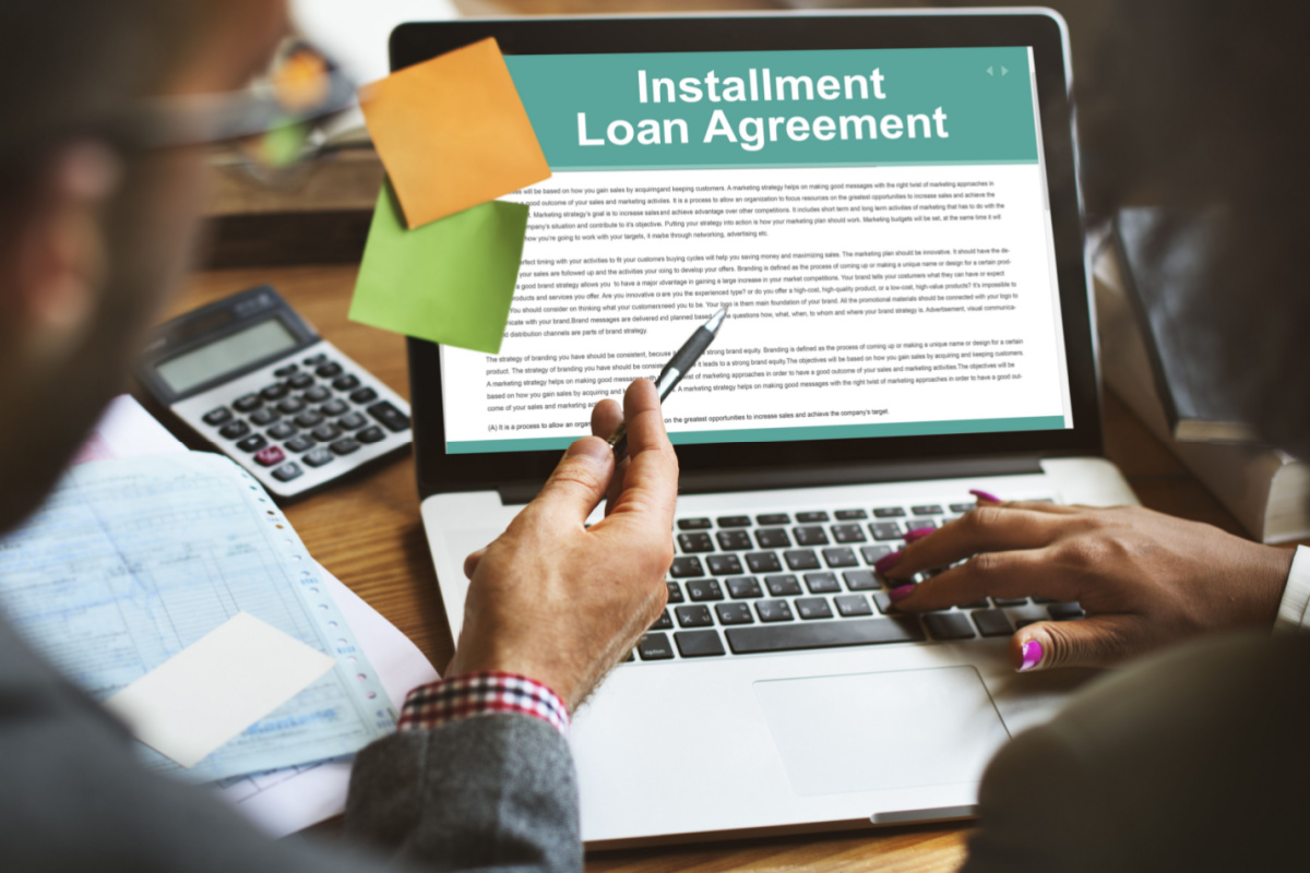 Individuals reading installment loan agreement online