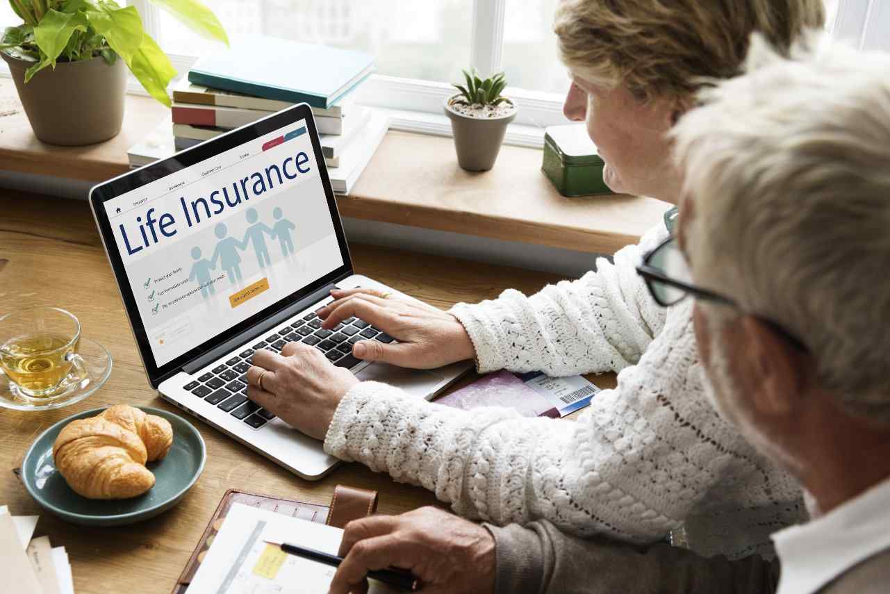 Couple signing up for life insurance on laptop