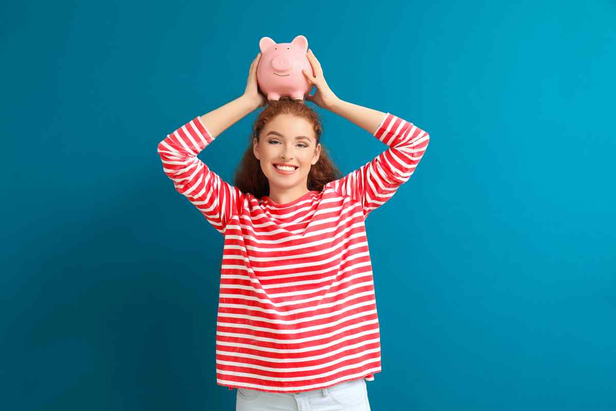 Woman holding a piggy bank on her head.