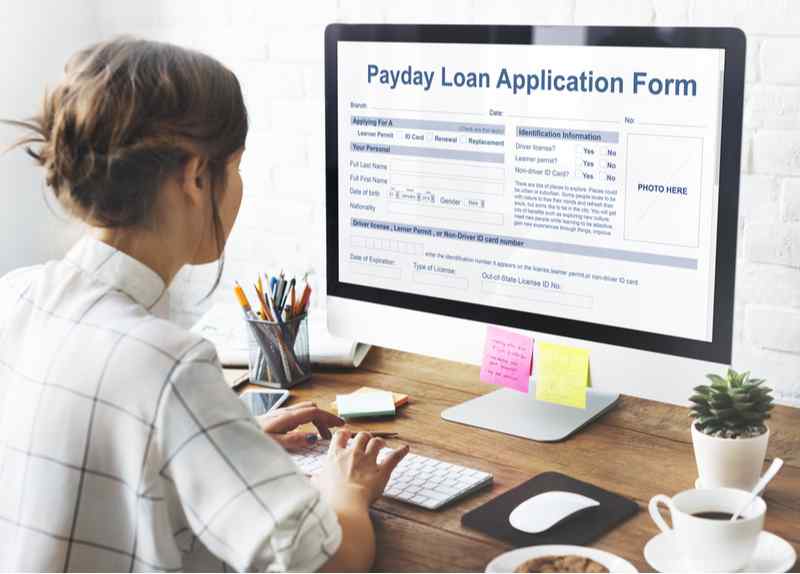 Woman filling out a payday loan application online.