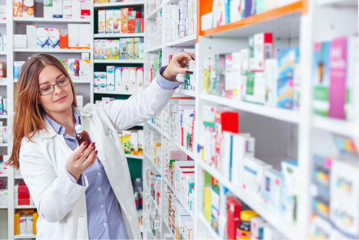 Pharmacist pulling orders from the shelf.