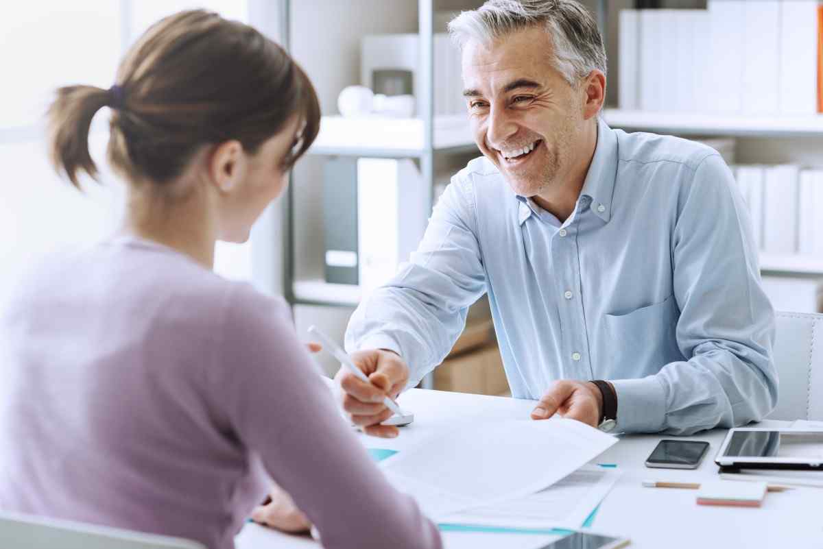 Man explaining what is 401(a) plan to a woman sitting in front of him