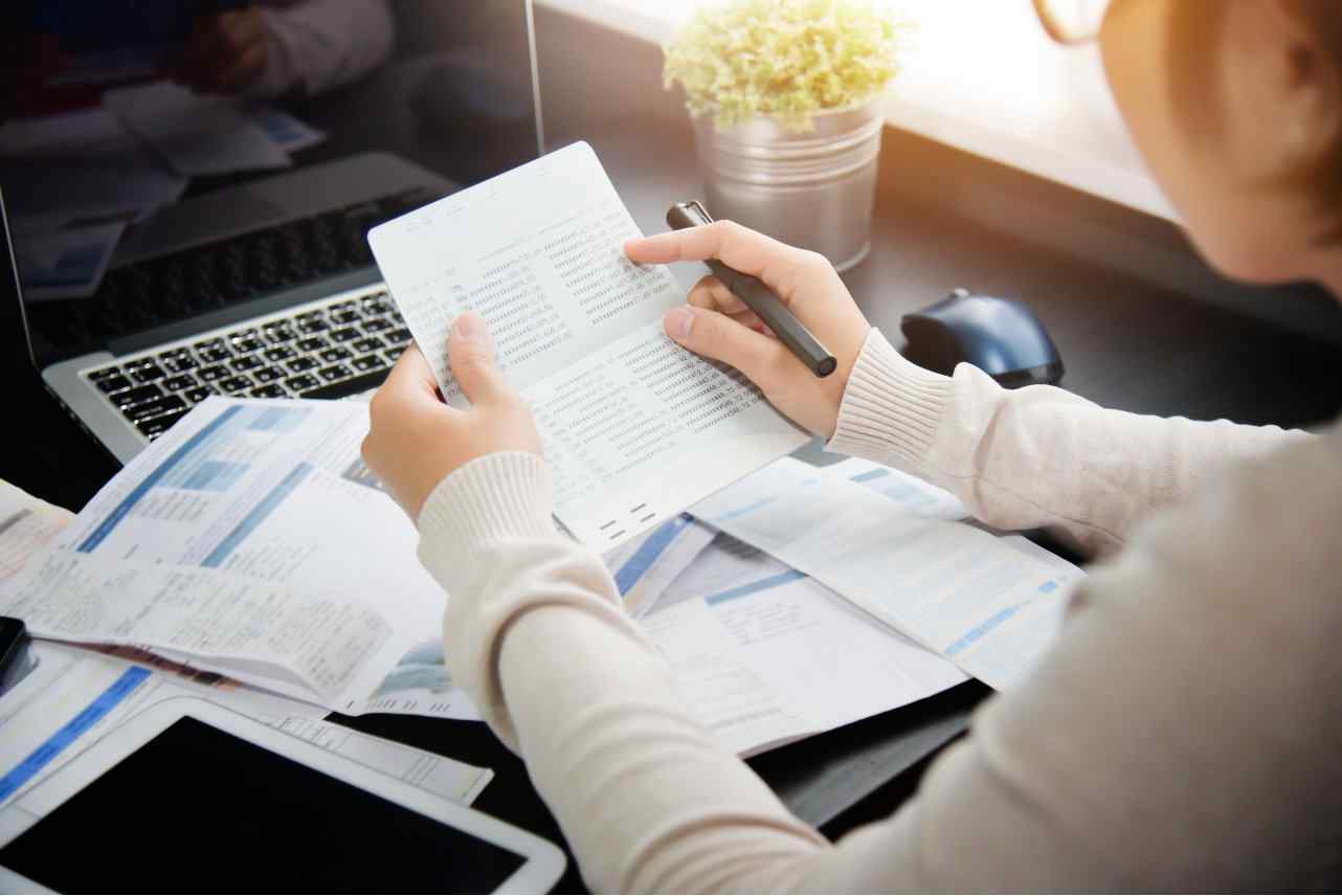 Individual holding check book and bill statement 