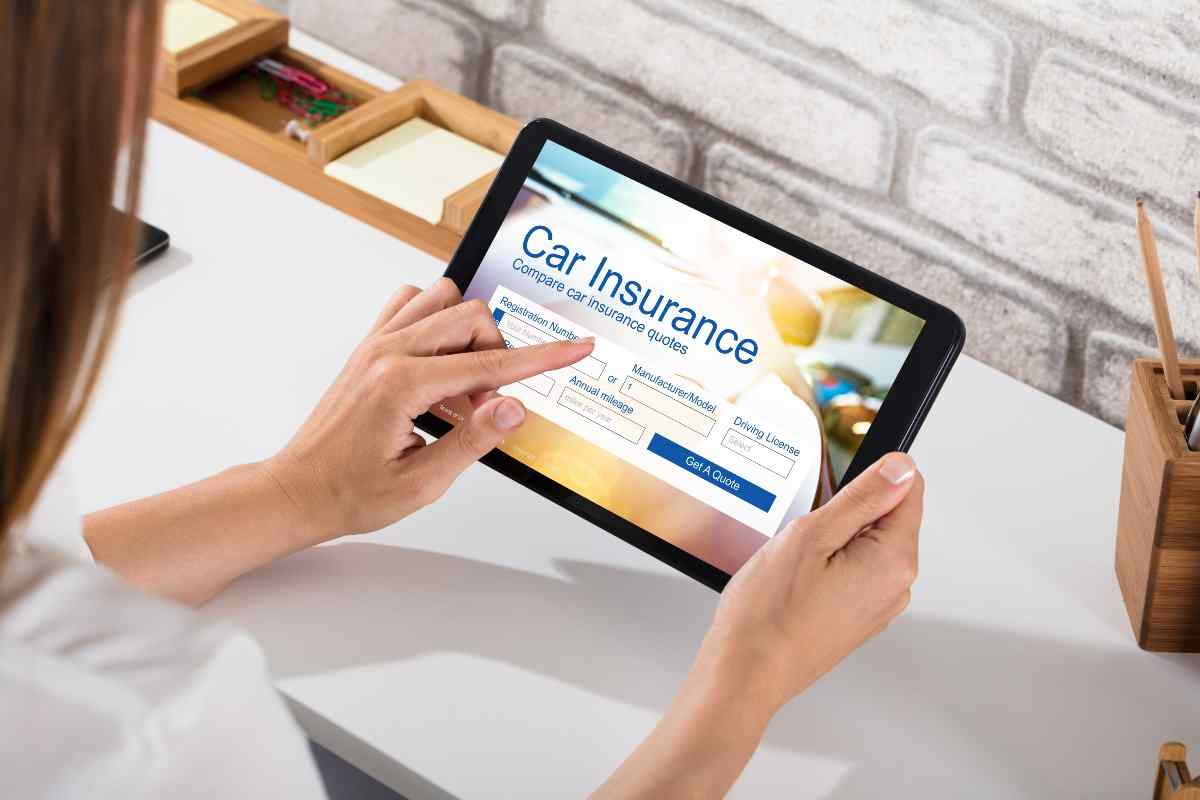 Individual comparing car insurance on tablet