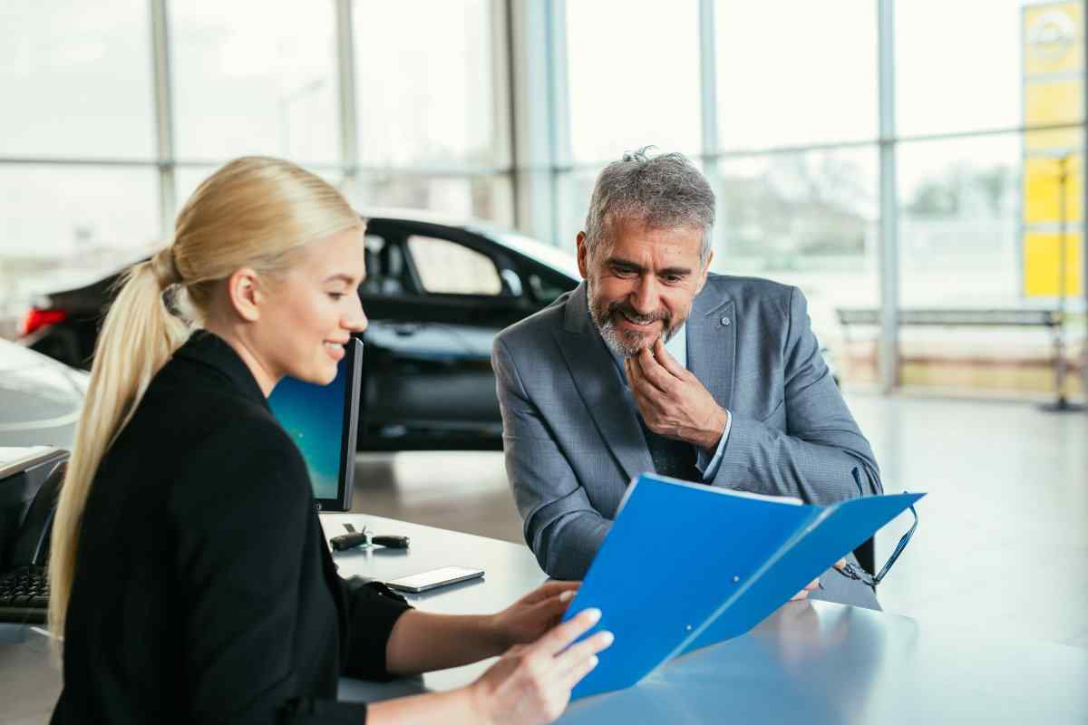 Salesperson presenting car lease agreement to customer.