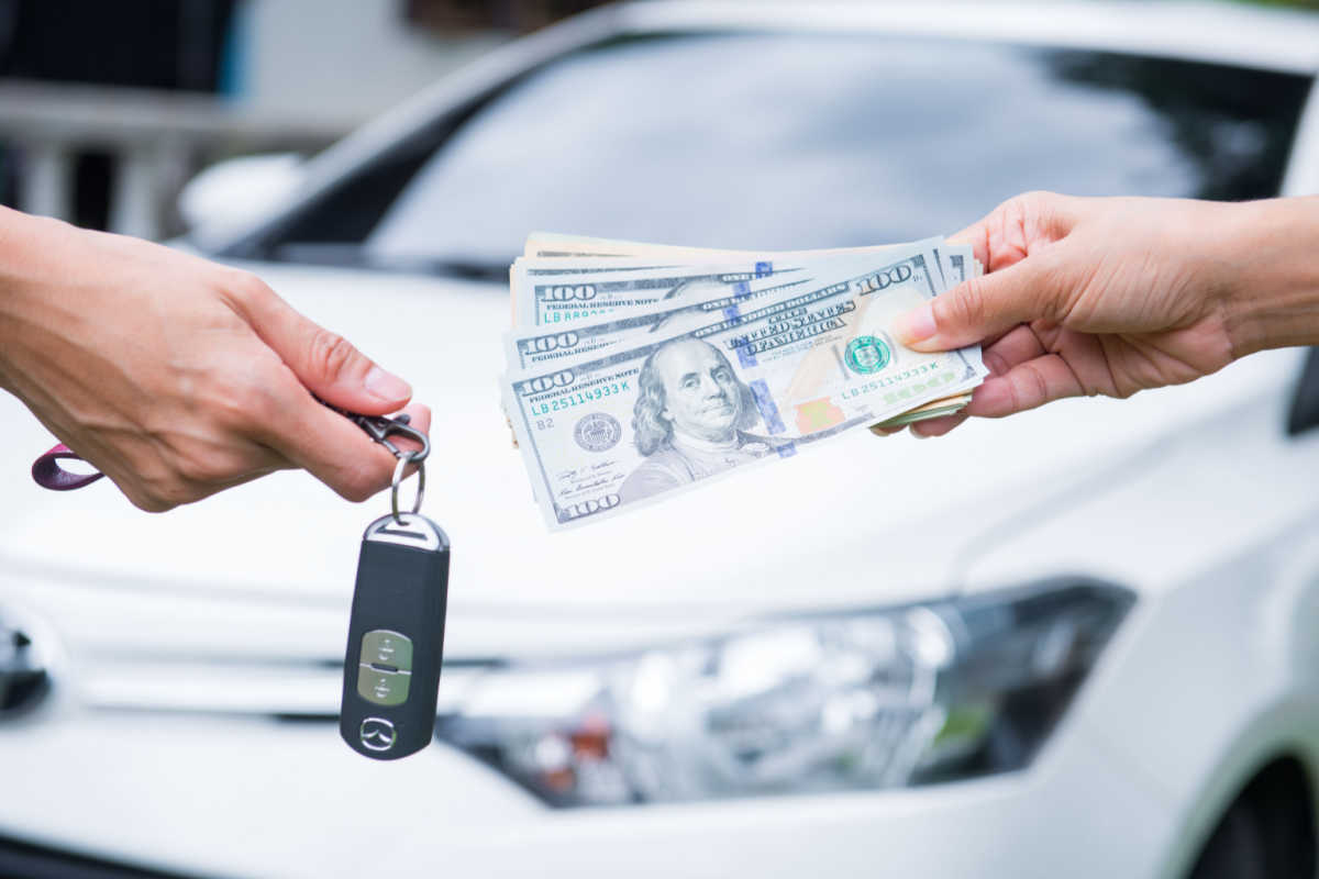 Close up on hands exchanging money and car keys 