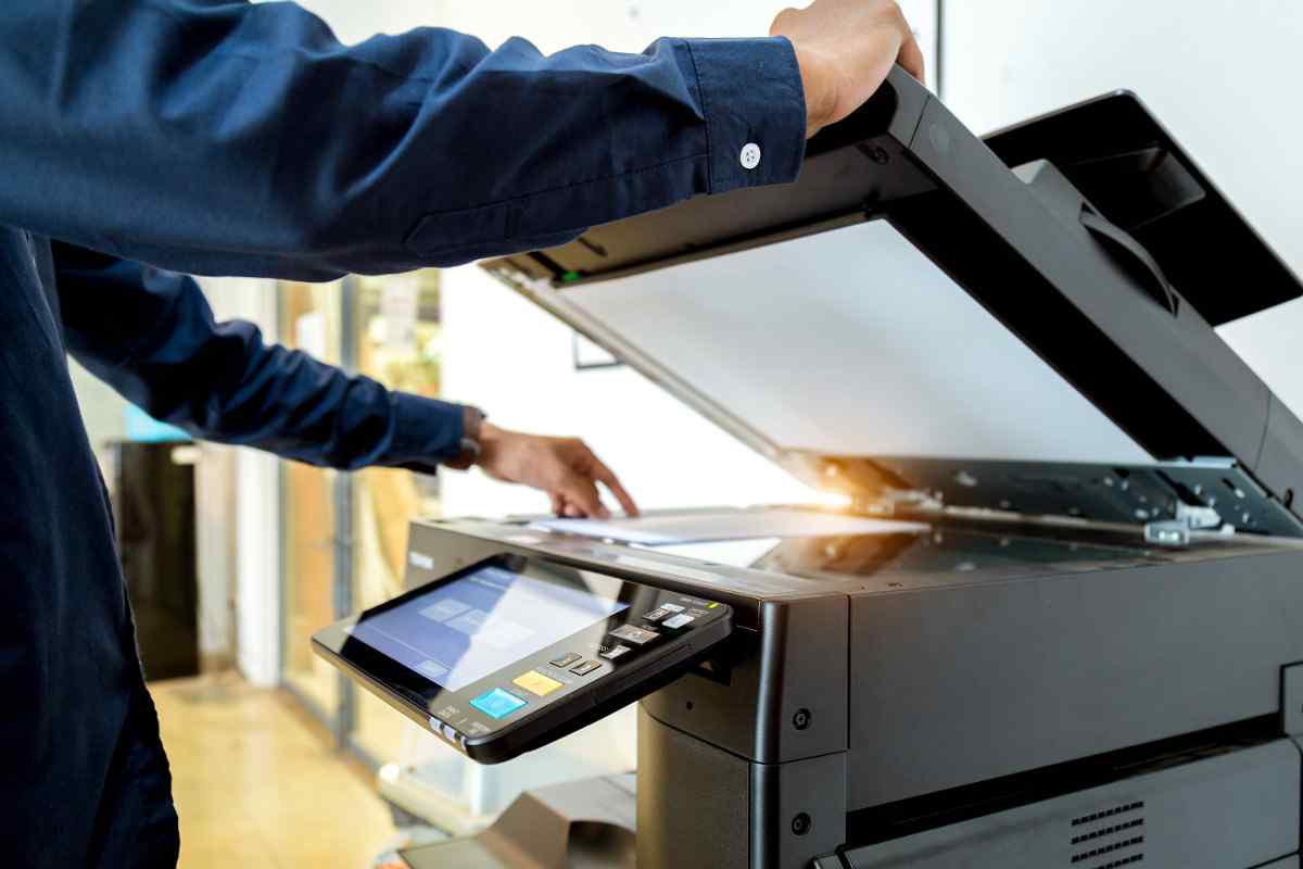 Man using a copy machine to send a fax.