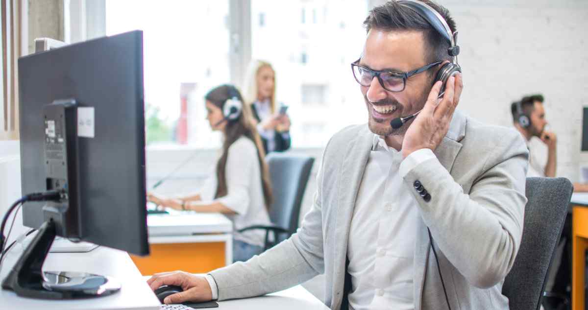 Customer service agent smiling on the phone.