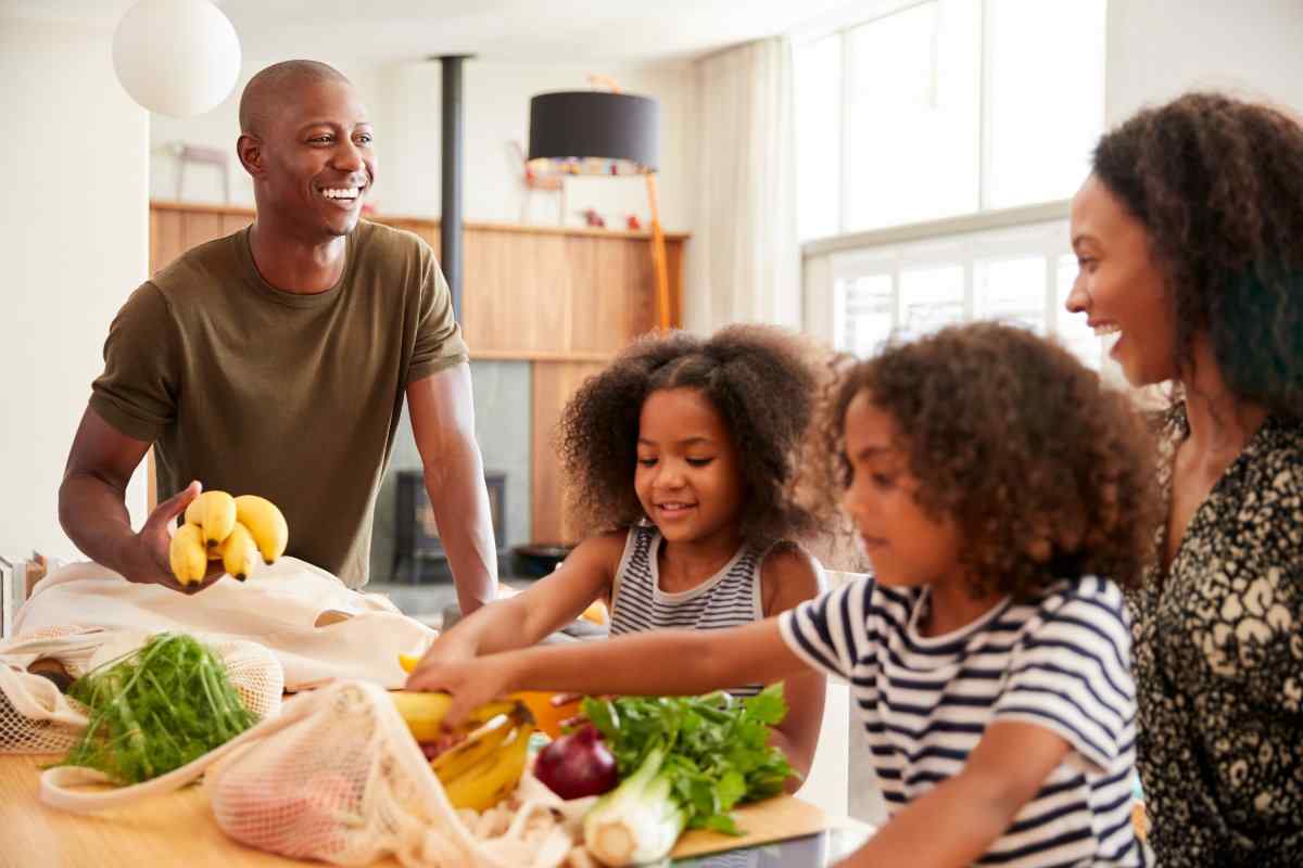 Smiling family unpacking groceries.