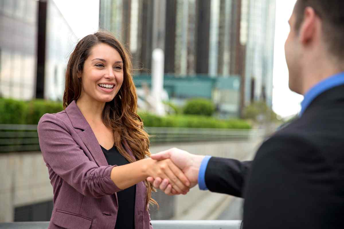 Two business people meeting on a city street.