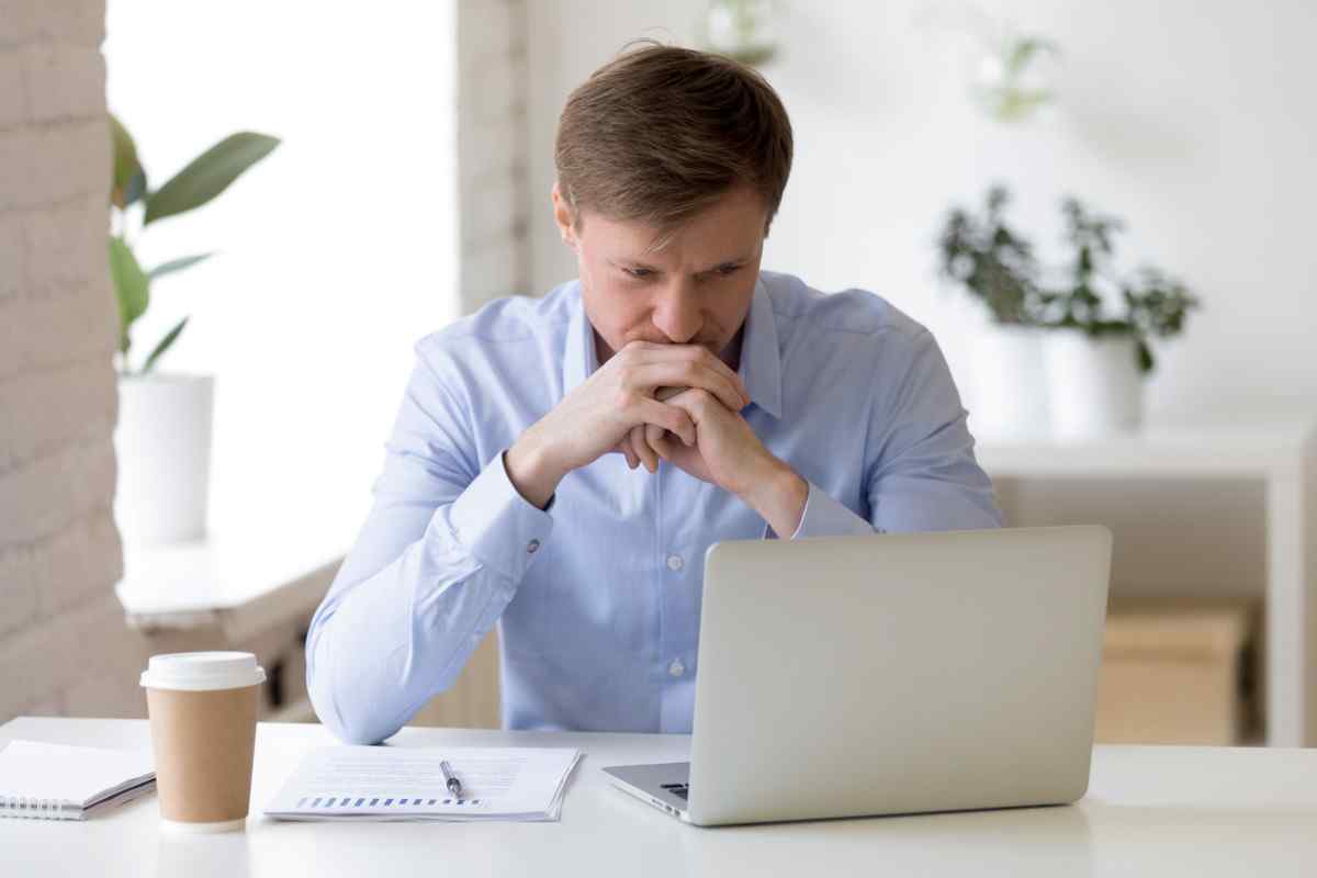 Man looks at laptop screen.