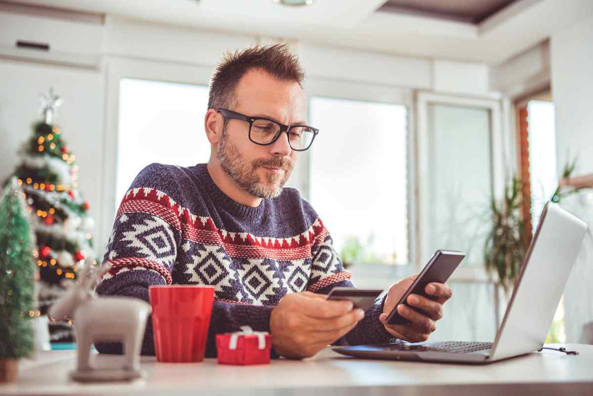 Man looking up holiday loan amounts on his phone.