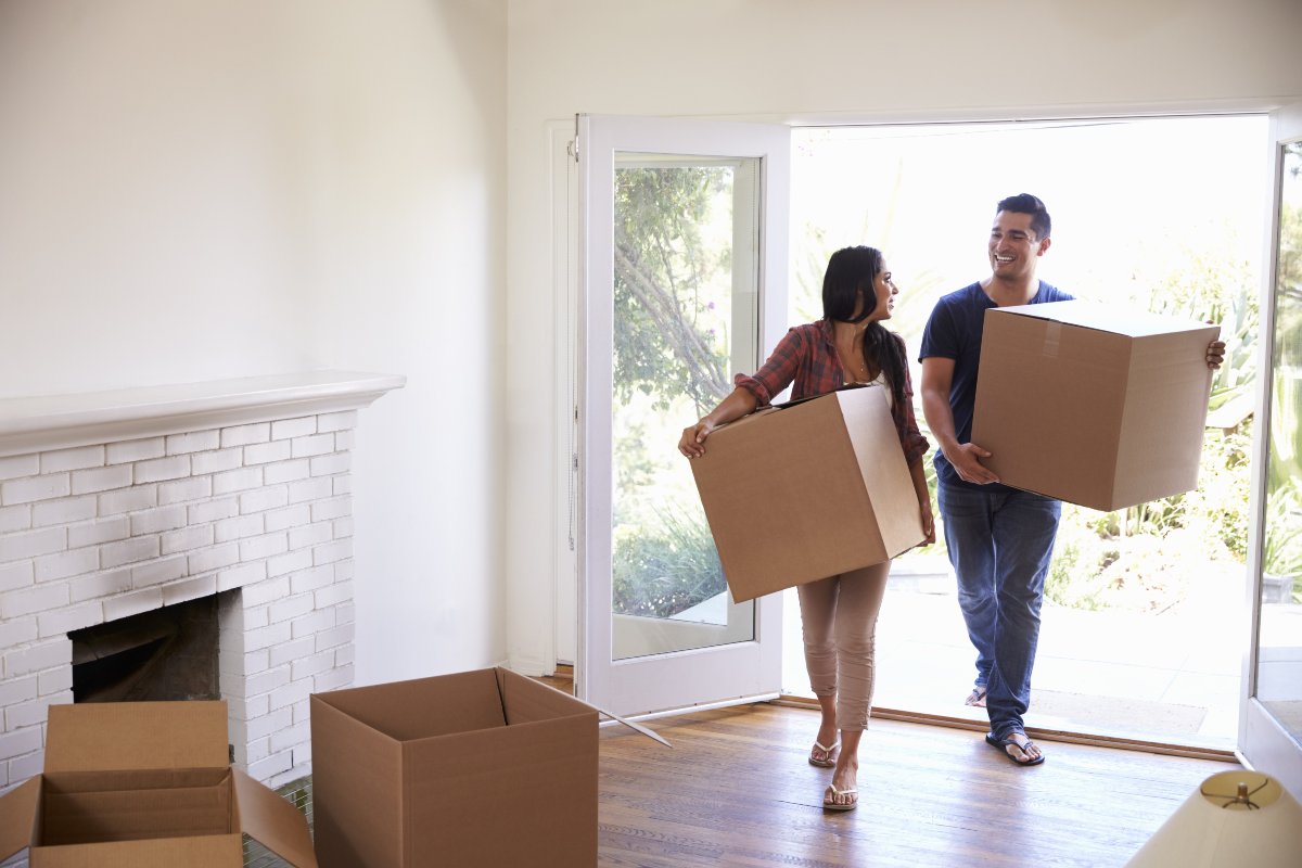 Couple moving boxes into new home