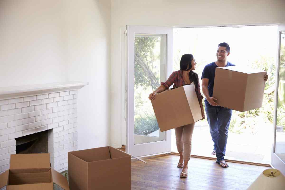 Couple moving boxes into new home 