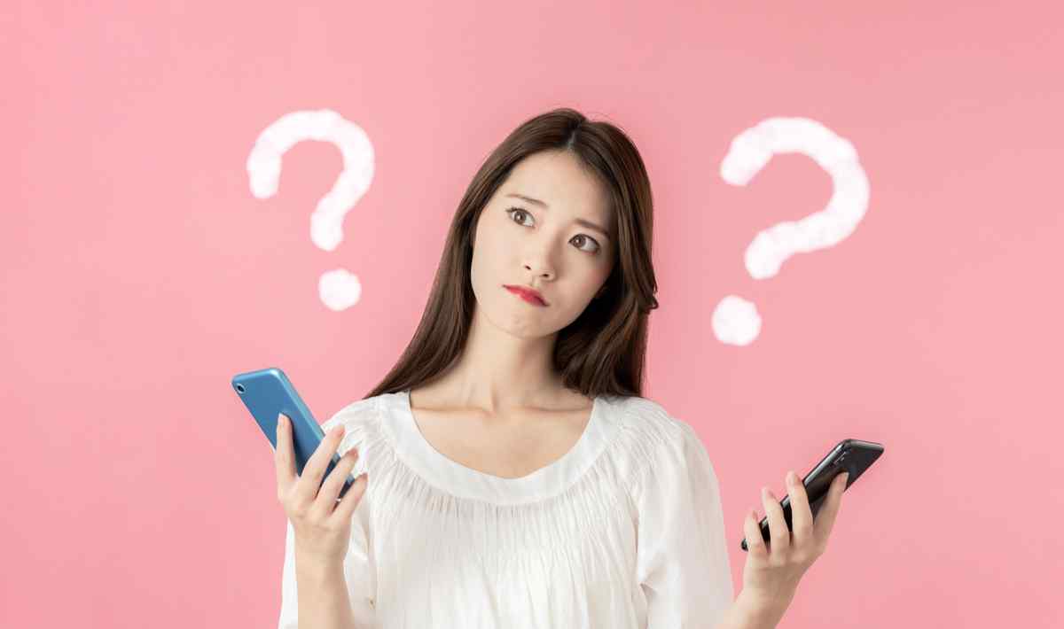 Woman pondering differences between scores on two phones.