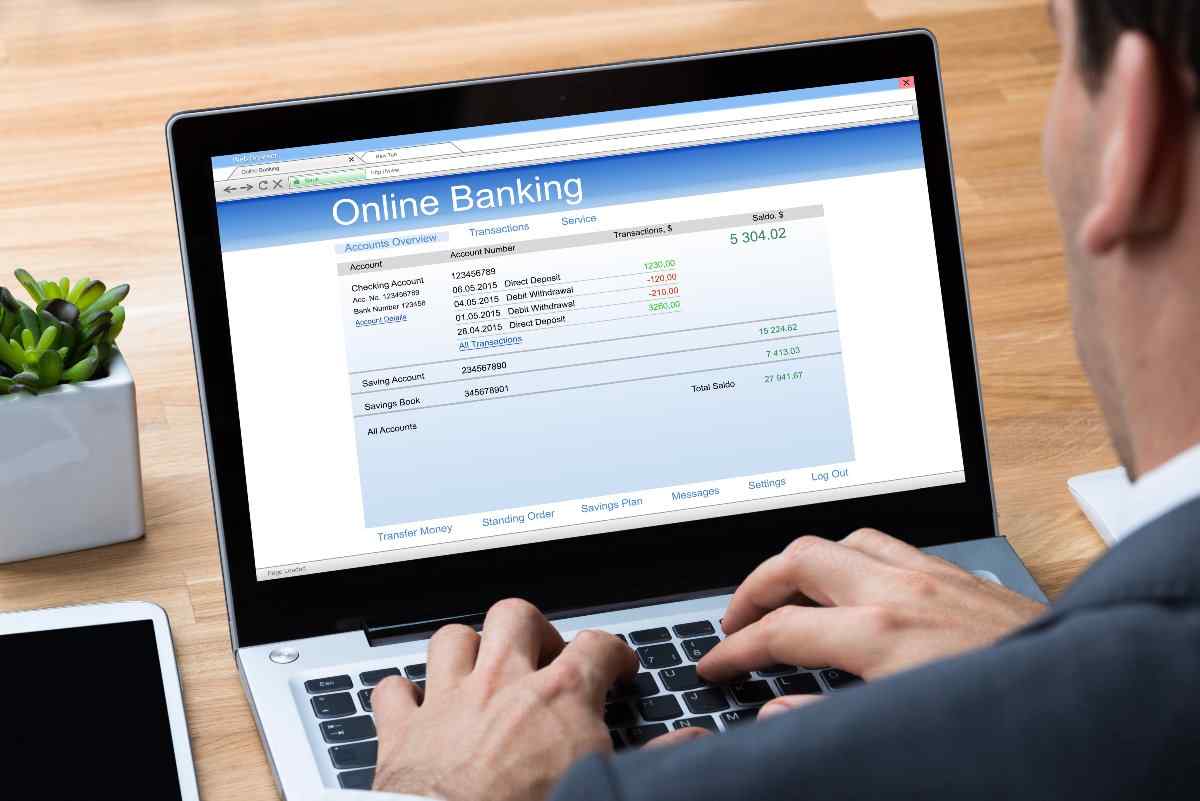 Individual checking online banking account on laptop