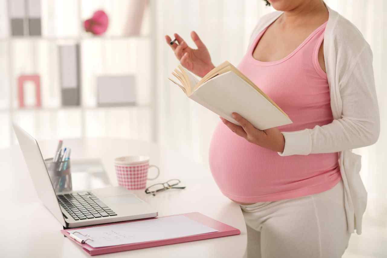 Pregnant woman reading book.