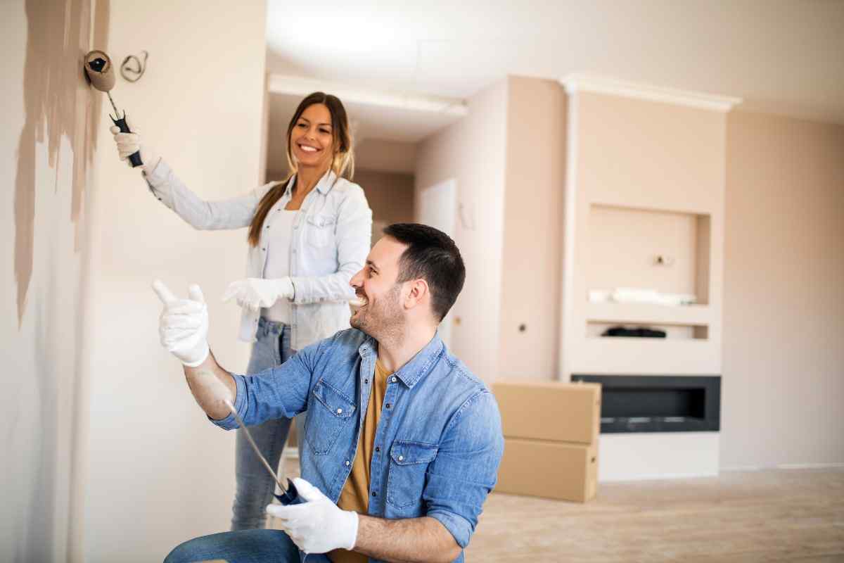 Couple painting living room.