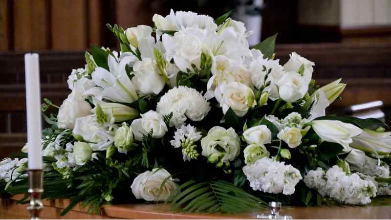 White flowers on coffin.
