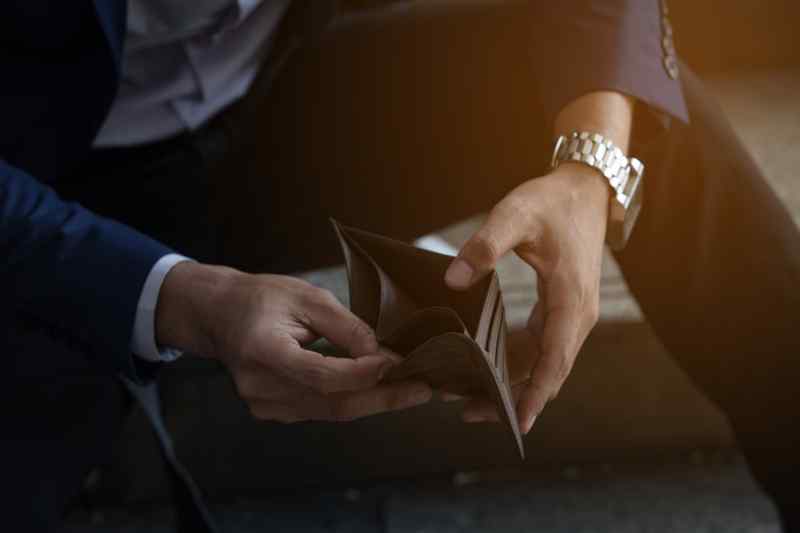 Man looking down at wallet.