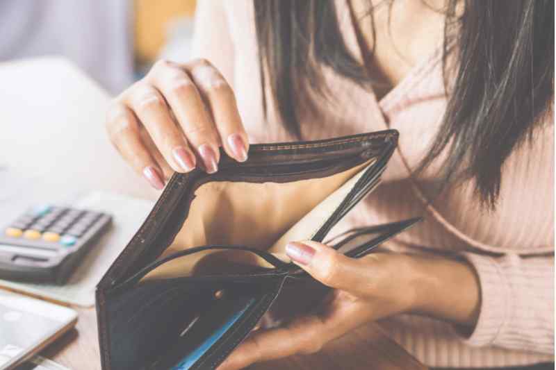 Woman opening an empty wallet.