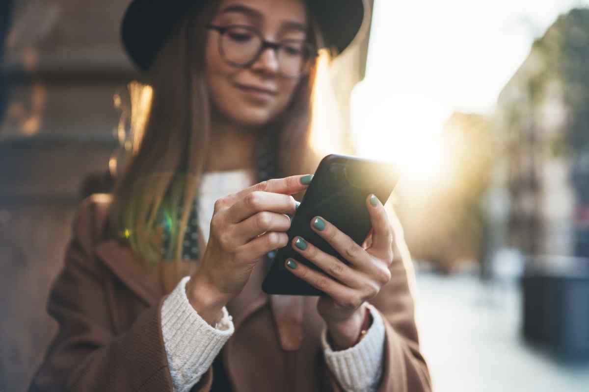 Smiling young adult holding cellphone.