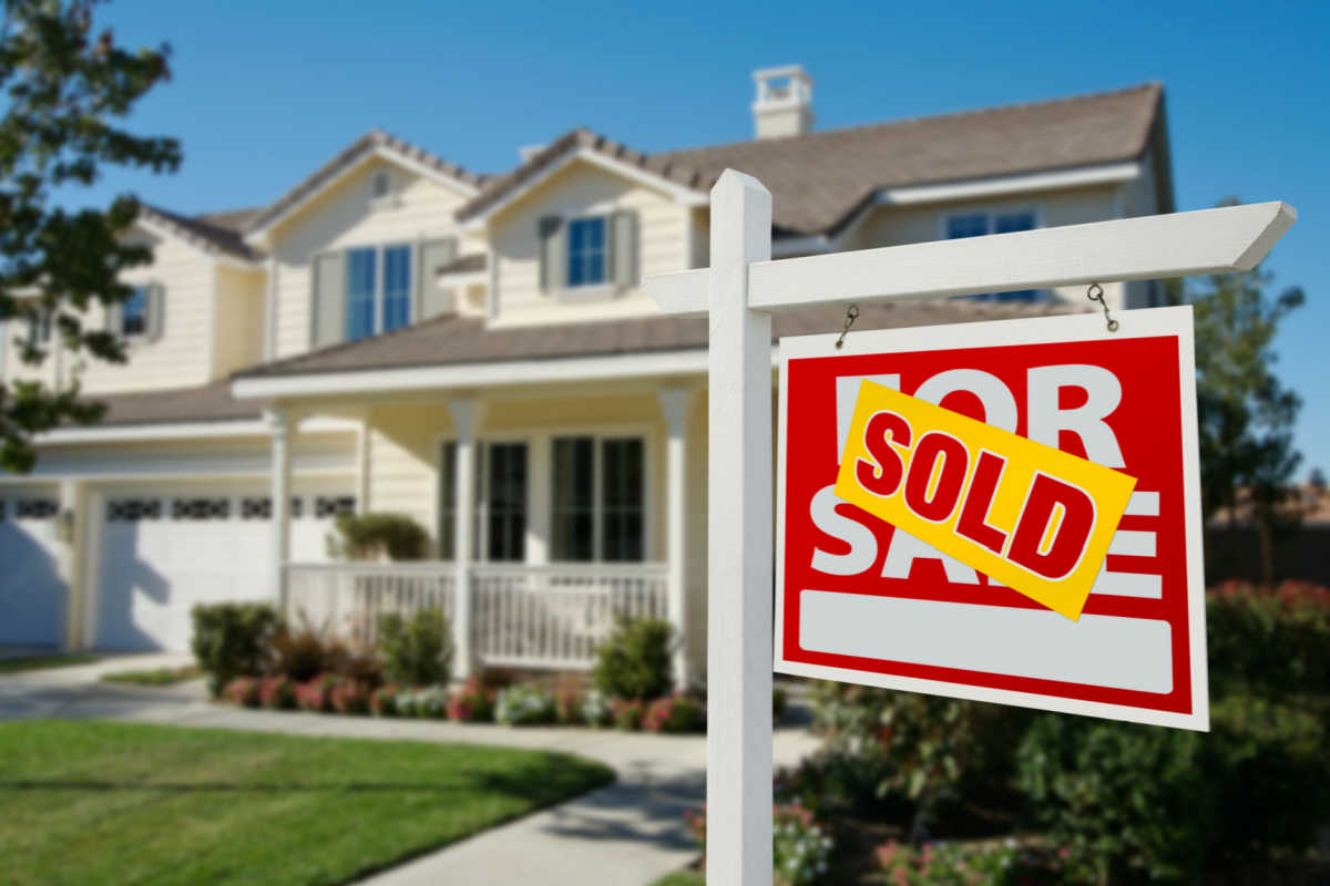 House with sold sign on lawn