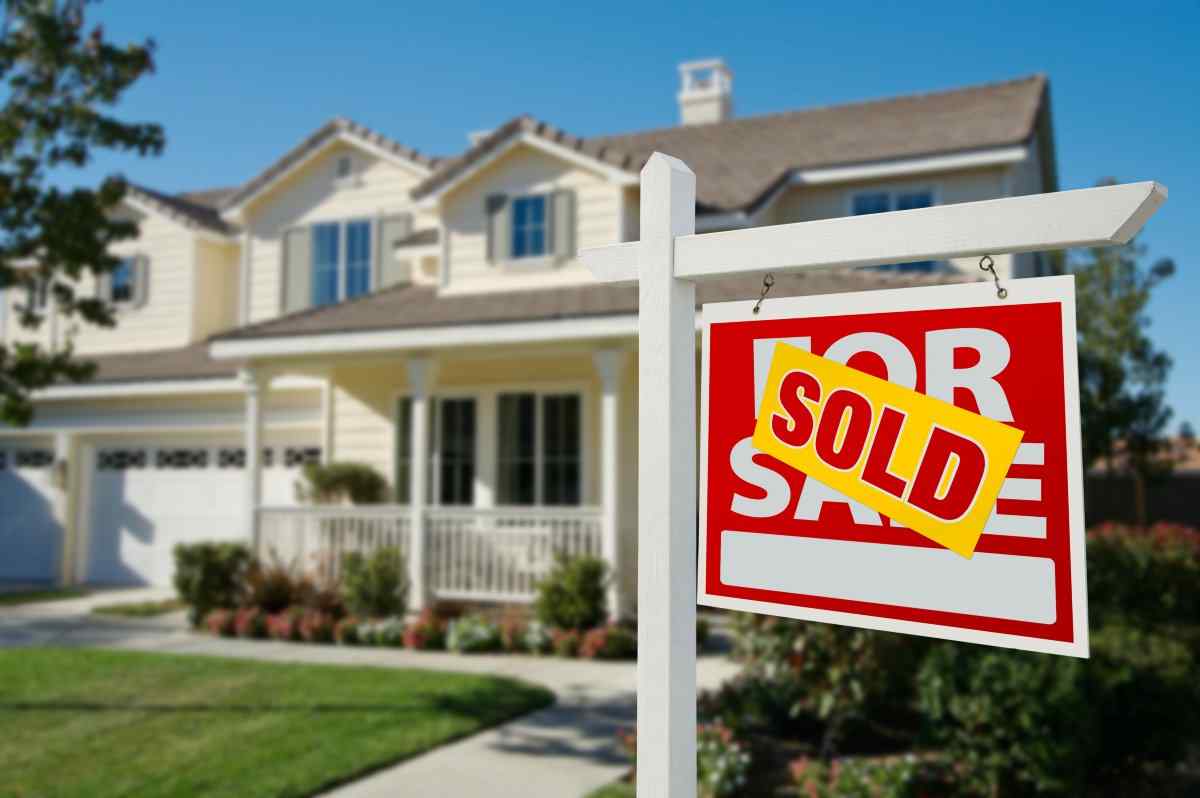 House with a sold sign on lawn