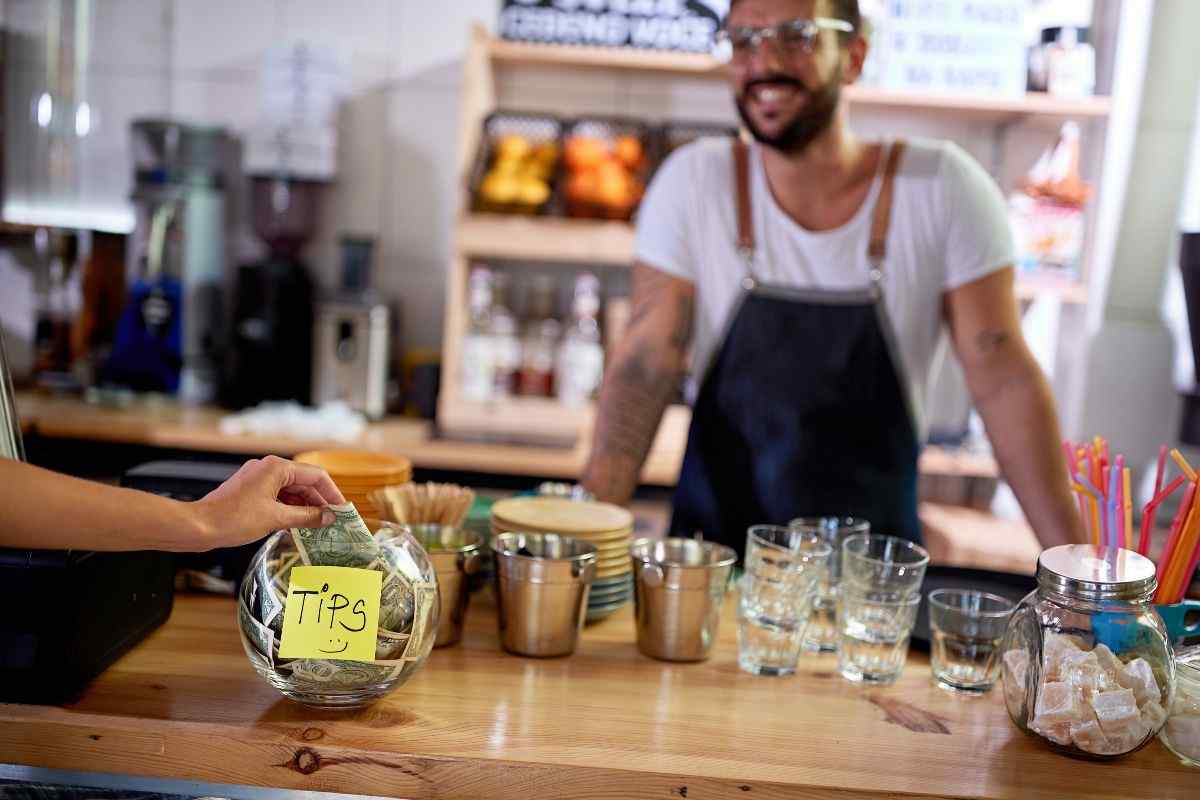 Individual putting money in tip jar 