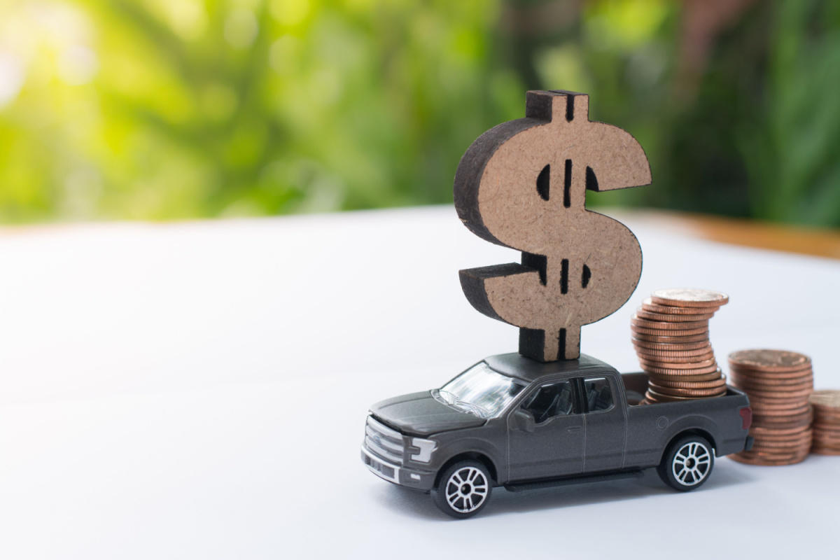 Miniature truck with wooden dollar sign and coins