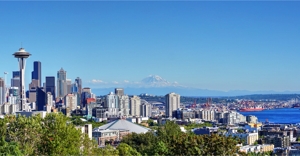 Cityscape view of the Space Needle and mountain range in Washington.