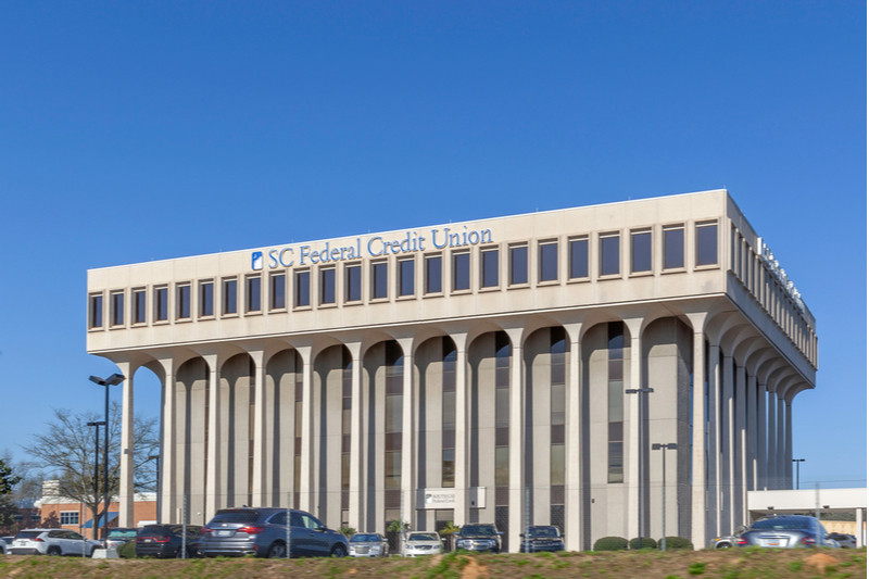 Credit union building with cars parked out front.