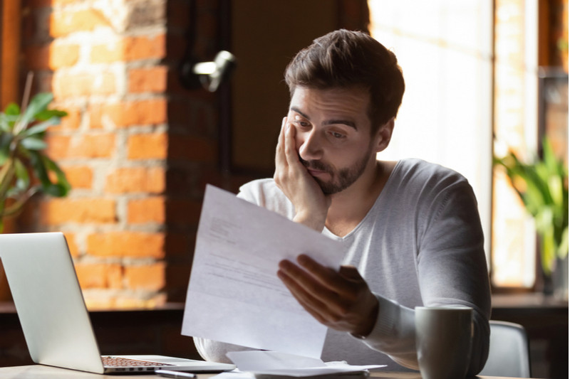 Man solemnly reviewing a financial document.