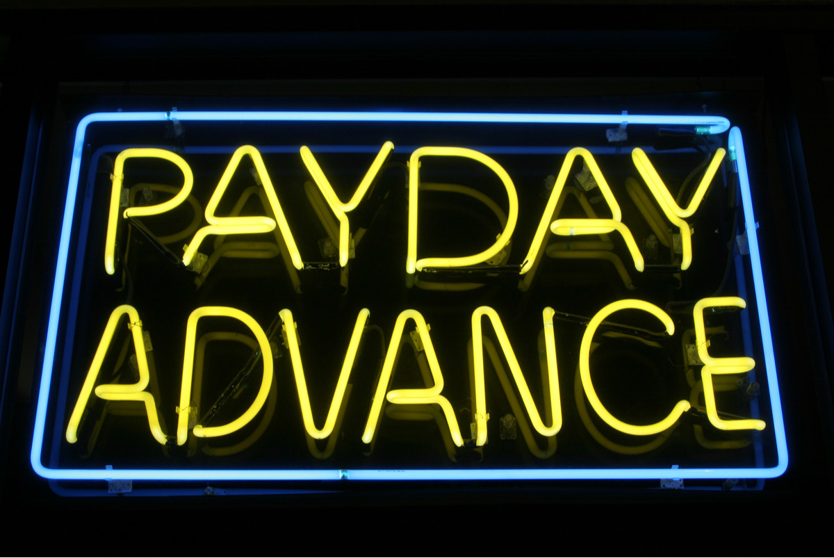 A neon sign for a payday loan storefront location.