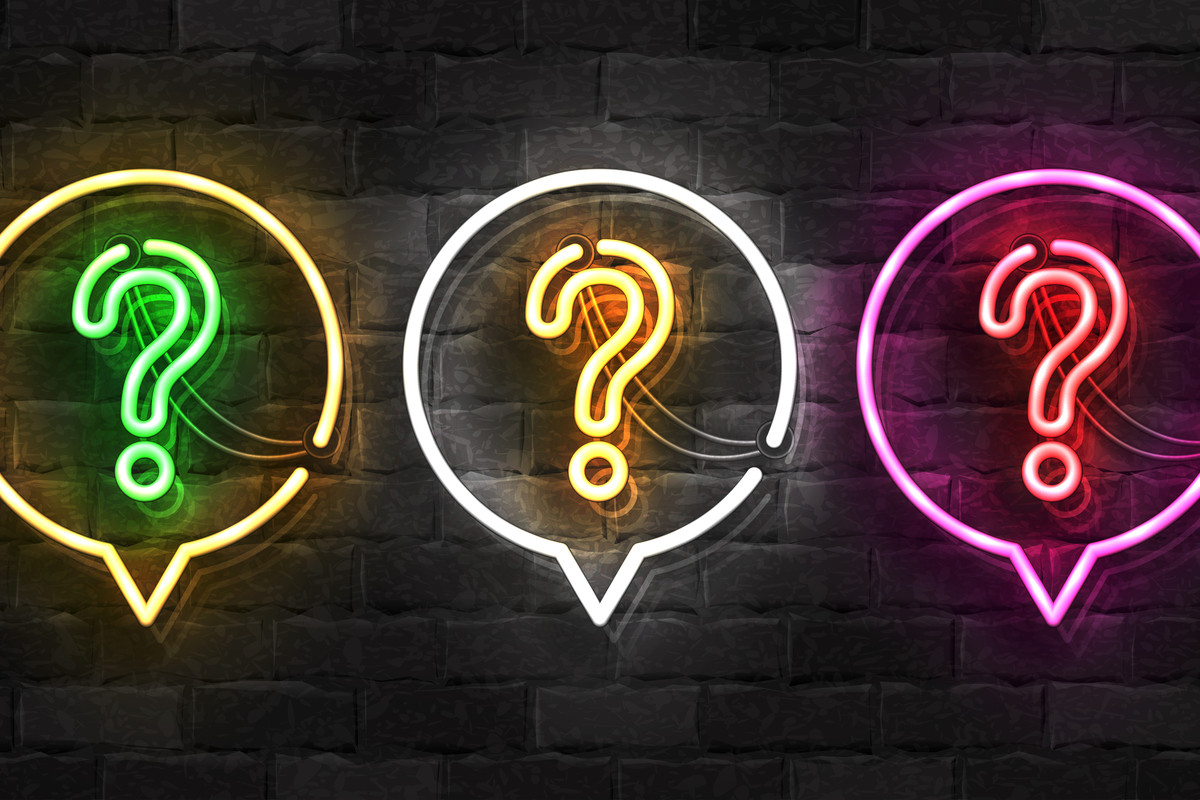 Question marks presented as neon lights against a brick wall.