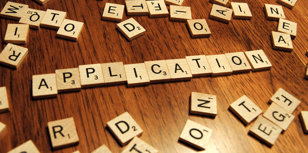 Letter tiles spelling out the word "Application."